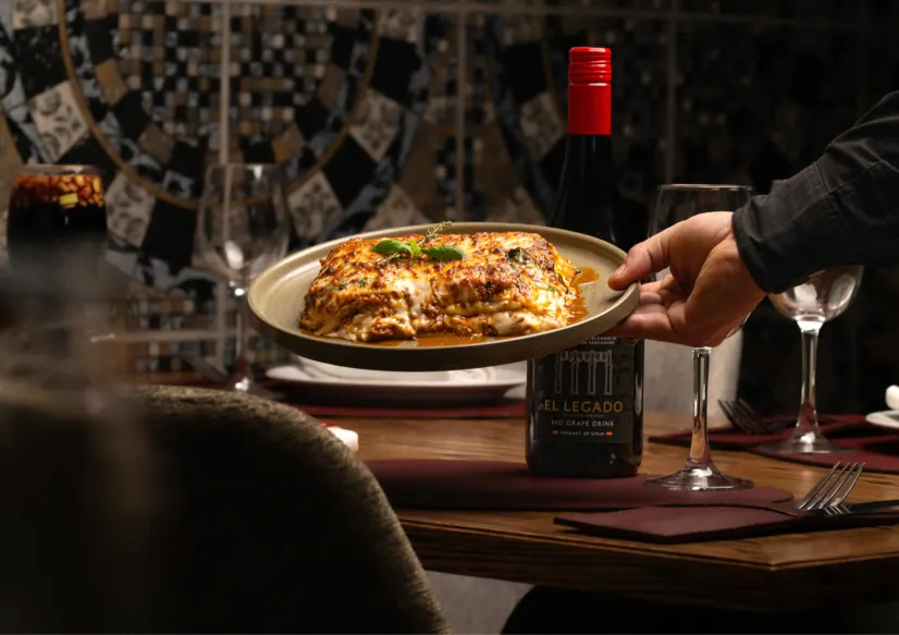 Mesa con un plato de pasta y vino