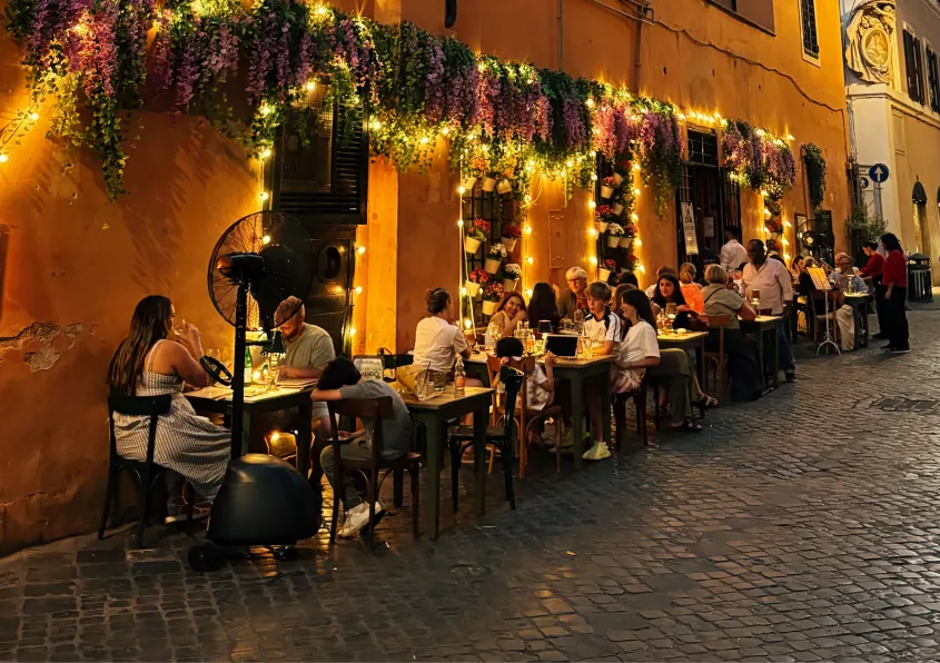 Callejón con terrazas de restaurantes iluminadas